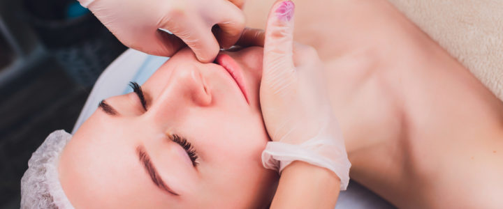 A woman lying on the massage table and practitioner is doing intraoral work.